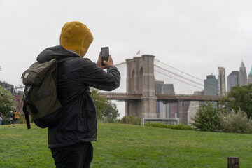 person taking photo of brooklyn bridge