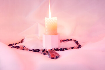 burning candle, a symbol of the moon, an amulet lying on a light natural background. pagan wiccan, slavic traditions. Witchcraft, esoteric spiritual ritual. autumn equinox festival