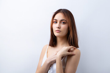 Naklejka premium Beautiful smiling woman with clean skin, natural make-up and white teeth on a gray background