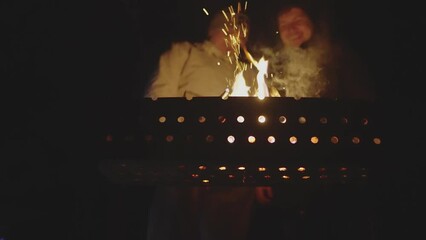 Two men are talking over a brazier. Focus on the brazier