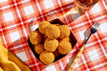 Typical Sicilian street food arancini (deep fried rice balls with meat) on paper plate take out. Unhealthy food.
