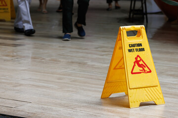 wet floor sign with water drops on wet stone floor. plastic sign warning.