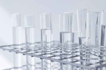 clear substance in scient glass tubes in stainless steel rack on white background. concept: energy...