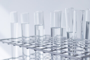 clear substance in scient glass tubes in stainless steel rack on white background. concept: energy fluid labrolatory for education recher and development.