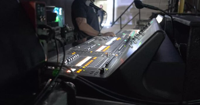 Hombre operando consola de sonido y audio en evento corporativo, social, concierto y espectaculo