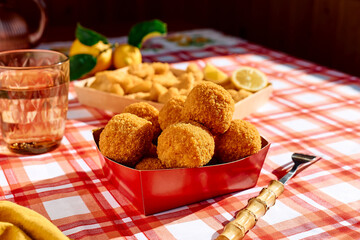 Typical Sicilian street food arancini (deep fried rice balls with meat) on paper plate take out. Unhealthy food.