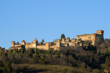 The castle of Gradara seen from afar with copy space in the sky. Gradara is a middle age italian village near Urbino famous for the stoy of Paul and Francesca in Dante Alighieri’s Divine Comedy - 566329946