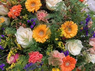 Bunte Blumen im Trauerkranz nach Beerdigung auf dem Friedhof