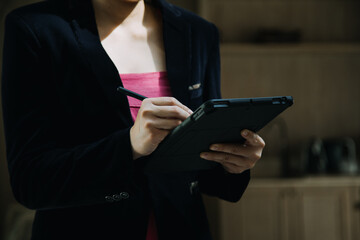 Mature businessman using a digital tablet to discuss information with a younger colleague in a modern business lounge