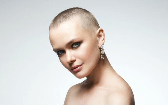 beautiful young woman with short haircut. bald girl with stylish jewelry earrings