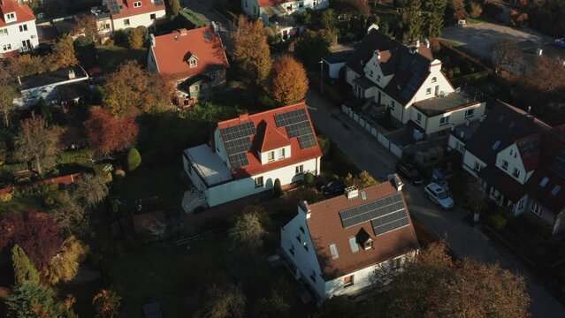 Drone shot over solar panels Photovoltaic solar panels mounted on the red roofs of country houses absorb sunlight as an energy source to generate electricity