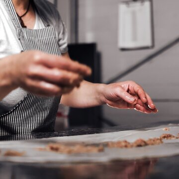 Woman Prepairing And Stretching Pizza Dough In Kitchen