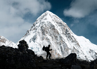 Man walking with backpack in the trek of Everest Base Camp, surrounded by the highest mountains in...