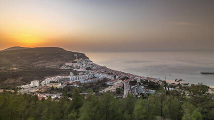 Aerial sunrise view of the coastline of the village of Sesimbra timelapse. Portugal