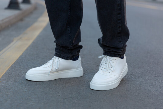 Stylish man in white sneakers shoes on city street
