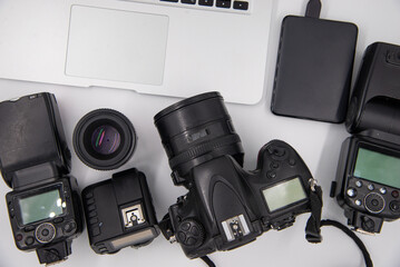 top view of work space photographer with digital camera, flash, cleaning kit, memory card, external...