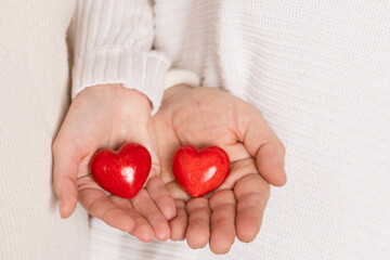 closeup hands holding heart on pink background, valentine's day concept