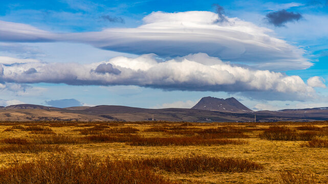 Unique phenomenon of a formed lenticular cloud (Altocumulus lenticularis) over a crater of volcano in the wild, empty scenery of southern Iceland, Europe