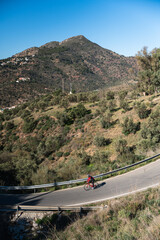 Cyclist ride a red bicycle on the road of the mountain during the morning
