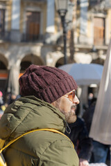 Beautiful winter portrait of a handsome man in a winter hat and winter clothes at sunset.