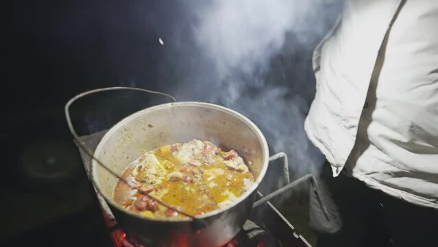 Boiling broth with ingredients is cooked on the grill