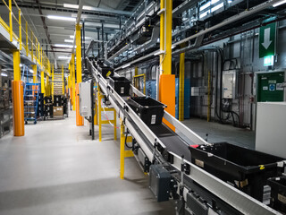 conveyor belt in the Warehouse with black totes with goods inside