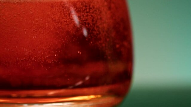 Whiskey, brandy or cognac pouring into glass. Stock clip. Close up of transparent glass and alcohol drink.