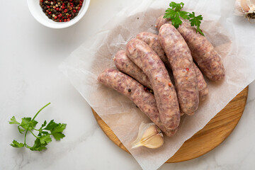 uncooked bbq sausage on wooden board top view food