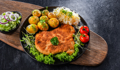 Pork cutlet coated with breadcrumbs with potatoes and cabbage