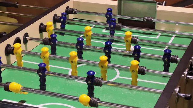 Table football in the entertainment center. Medium shot of plastic players in a foosball, baby-foot, subbuteo, table soccer, or foozeball