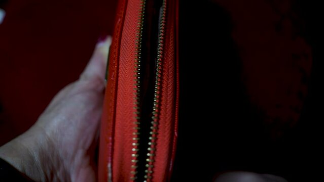 A girl opens her purse. She unhooks her purse. Financial problems. No money. A crisis.