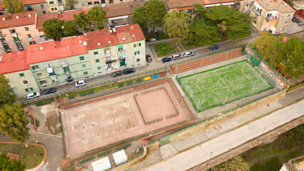 Fototapeta premium Aerial view of a soccer field among the buildings of an Italian periphery.