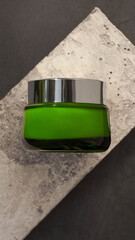 green glass cream tube on concrete background. Close up, your logo, mock up for cosmetics, mock up for designers, facial and body treatment, minimal mok up