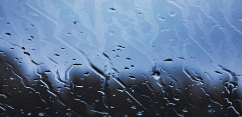 rain trops on the transparent glass window,abstrakt blue background,reflections on a glass,art background for design,