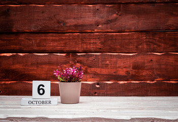 October calendar with number  6. Planner copy space on a wooden brown background. March number icon. Place for text background calendar