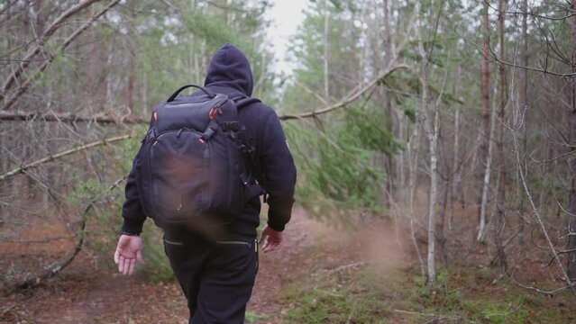 The guy makes his way through the trees in the forest