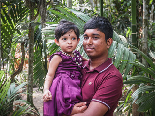 South asian young uncle holding his niece in arm in outdoor 