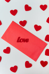 A love letter, the inscription of love on a red paper envelope on the background of small red hearts. The concept of St. Valentine's Day.
