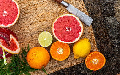 top view of assorted citrus split and with wooden board and knife, wallpaper, healthy eating, vitamin C.