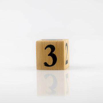 number 3 three  Wooden cube with number isolated in white with reflections. Numeral cubes with numbers..