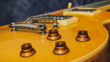 Yellow Les Paul electric guitar on a fur background close up of volume and tone knobs