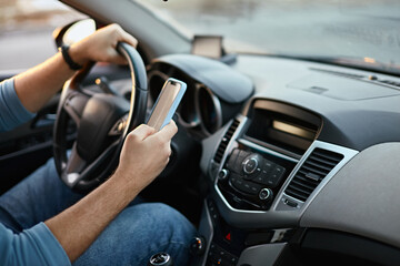 Hands of unrecognizable man driver using mobile phone while driving - Powered by Adobe