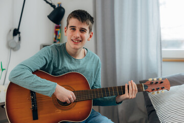 Front view of a teenage boy playing the guitar