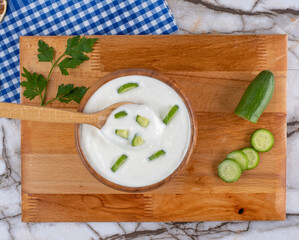 Top View Traditional Greek or Turkish Yogurt Sauce in A Bowl On Marble Background. Kitchen Concept Tzatziki on Marble Floor. (Turkish name: Cacik)