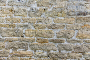 An old cobbled wall, stone masonry. Abstract natural backgrounds and textures