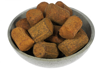 Dutch cinnamon candy sticks in a concrete bowl isolated on white background
