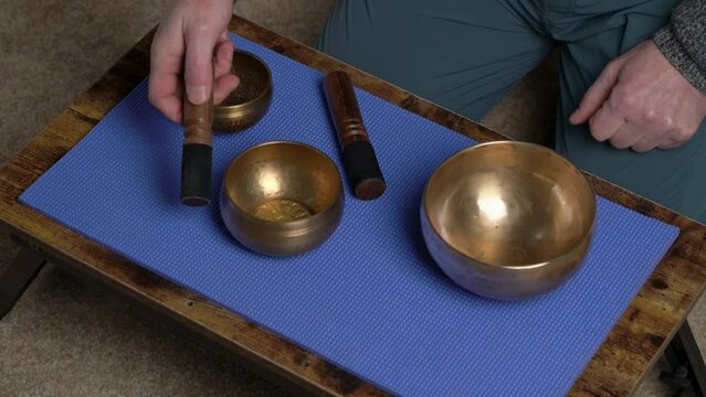sound healing with Tibetan singing bowls with hands of a senior male