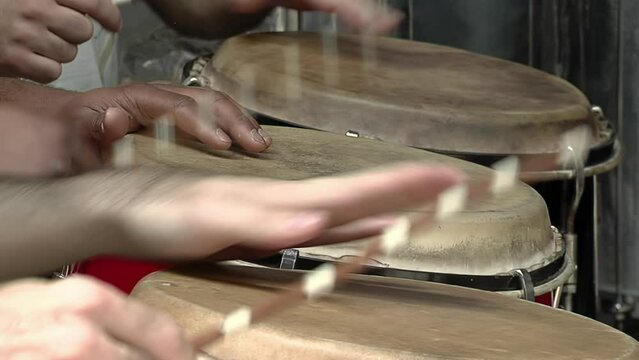 Latin Percussionists Playing Drums using their Hands and Sticks. Close Up.