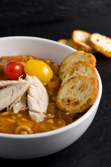 Close-up Image of Homemade Chicken Paste Soup with Tomatoes and Crackers