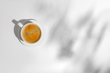 Hot coffee cup, mug of cappuccino, latte in hard light on white background with shadow, top view,...